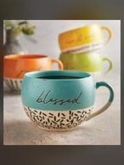 A close up of a cup with the word blessed written on it