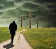 A person walking down the road towards three crosses.