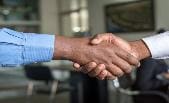 Two people shaking hands in a room.