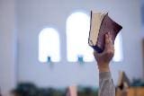 A person holding up a book in the air