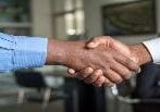 Two people shaking hands in a room.